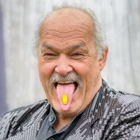 Älter Mann streckt Zunge mit Medcoat in Kamera